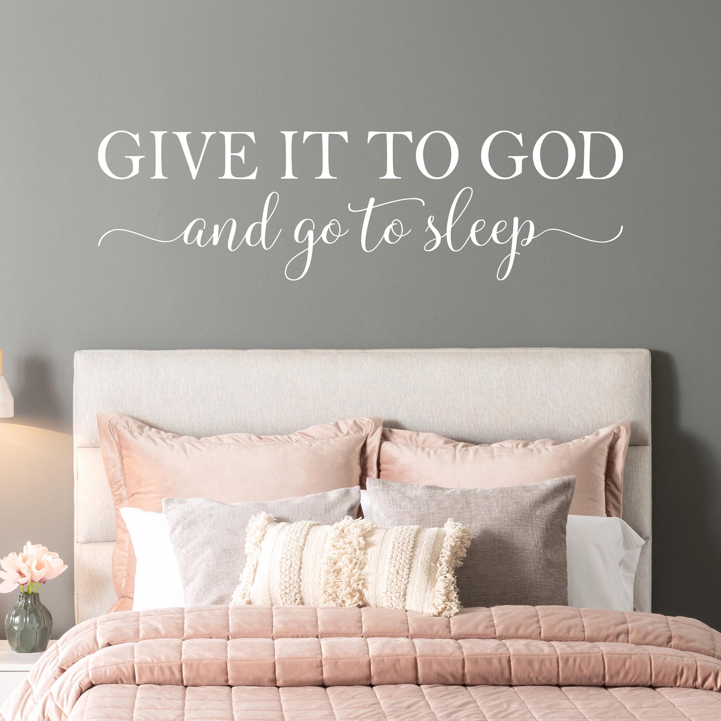 Inspirational Christian quote wall decal above a neutral-toned bed, perfect for a peaceful faith-filled bedroom. Give it to God and go to sleep quote.
